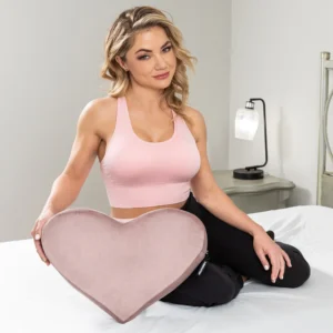 Beautiful woman sitting in bed with the rose Liberator Heart Wedge Sex Pillow